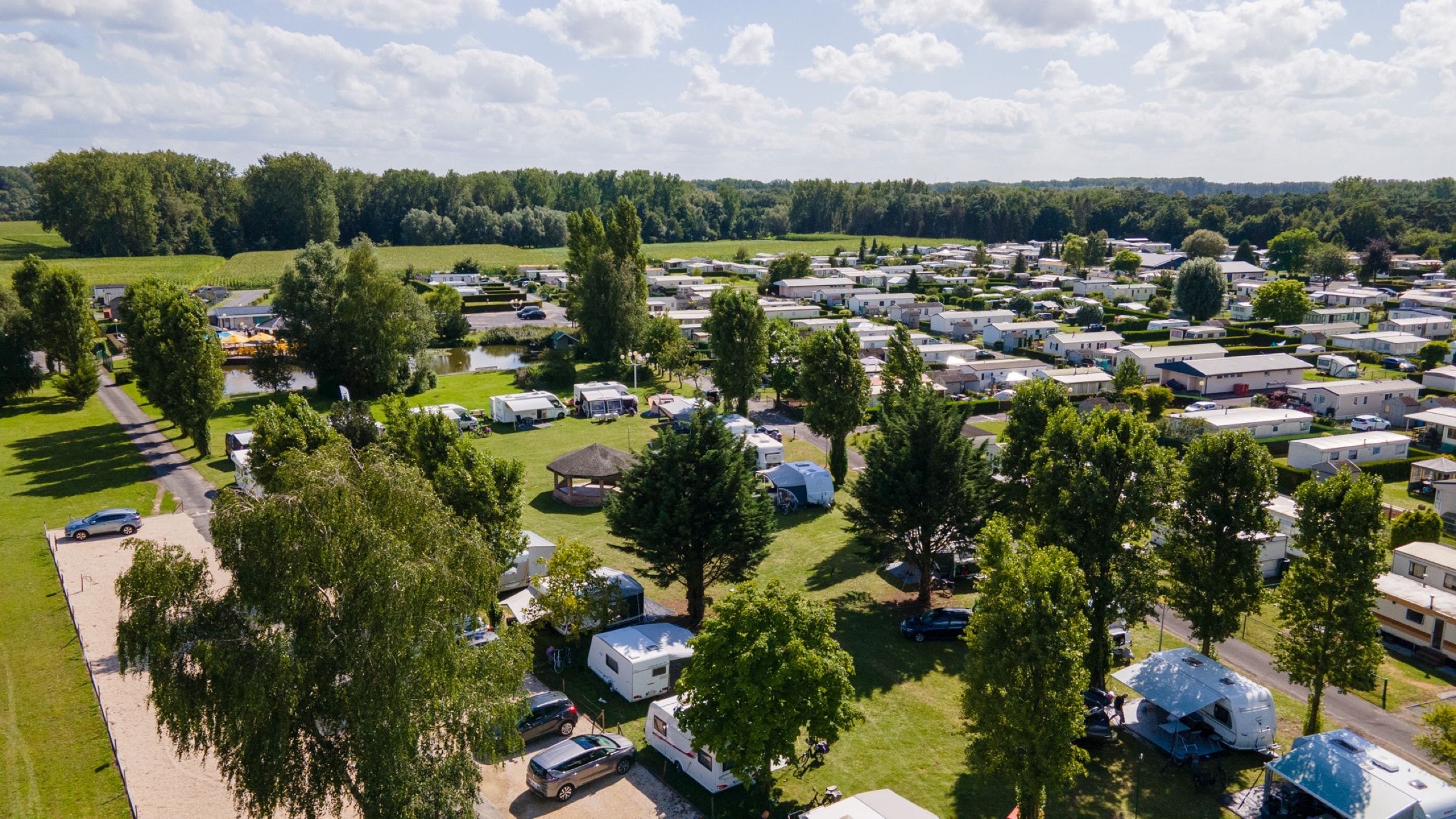 Luchtfoto van Camping Vlasaard met caravans, chalets en groene bomen