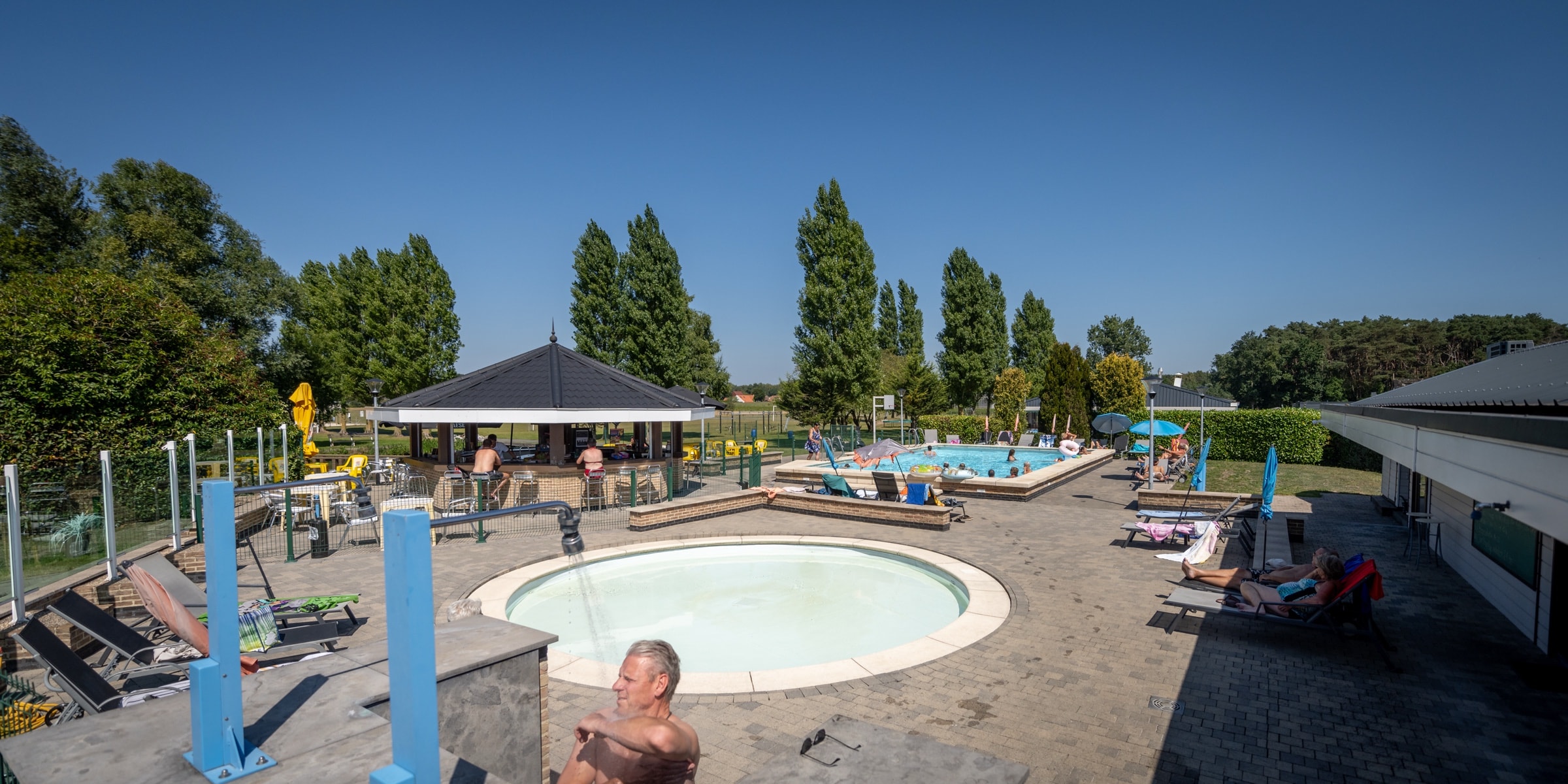 Buitenzwembad met bar en ligweiden op Camping Vlasaard